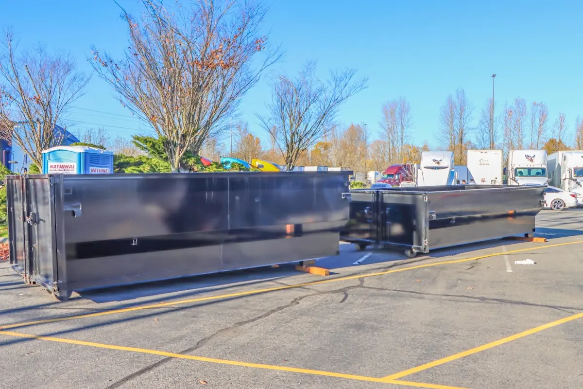 Professional dumpster rental service with roll-off container on residential driveway in East Bakersfield